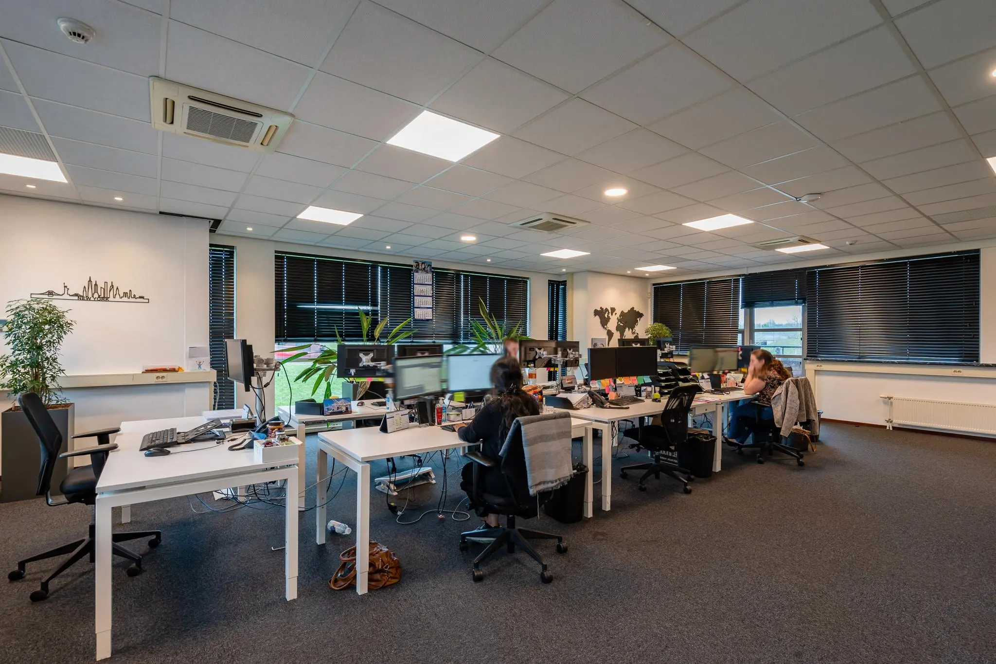 Moderne kantooruimte aan de 1e Barendrechtseweg met meerdere werkplekken, computers en medewerkers aan het werk.